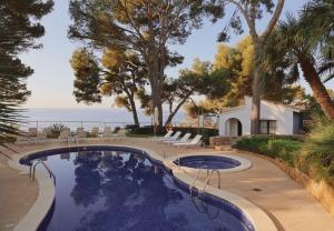 ein Swimmingpool mit Blick auf das Meer in der Unterkunft Hotel Bendinat in Portals Nous