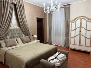 a bedroom with a large bed and a chandelier at La Dimora in Morino