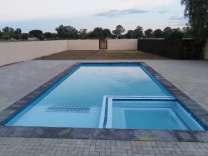 a large blue swimming pool in a backyard at Indawo Guesthouse in Bloemfontein