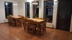 a dining room with two tables and chairs and windows at Casa Dancs in Covasna