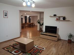 a living room with a flat screen tv and a table at Casa Dancs in Covasna