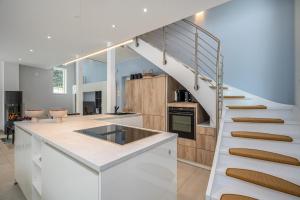 a kitchen with white cabinets and a staircase at Chalet Wacholder in Dierhagen