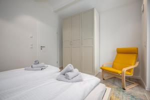 a bedroom with two beds and a yellow chair at Chalet Wacholder in Dierhagen