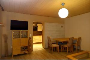 a dining room with a table and a flat screen tv at Ferienwohnung Saller in Weißenbrunn