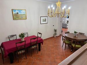 a dining room with a table and chairs and a chandelier at La Dimora in Morino