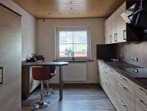 a small kitchen with a table and a window at Ferienwohnung Saller in Weißenbrunn