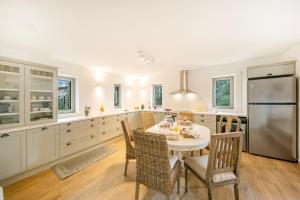 a kitchen with a table and chairs and a refrigerator at Villa Oliva with Private Pool by Konnect in Kato Korakiana