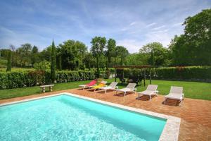 a swimming pool with chairs and a gazebo at Agriturismo Casal Gheriglio in Lucignano