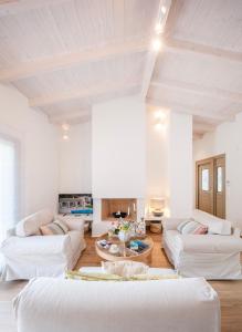 a white living room with white couches and a table at Villa Oliva with Private Pool by Konnect in Kato Korakiana +51 photos