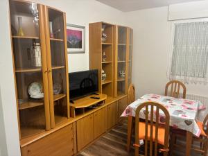 a dining room with a television and a wooden cabinet at Puentecuervo 3 in Pancorbo +1 photo