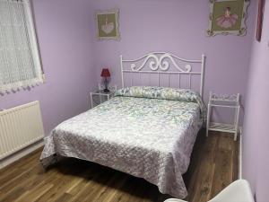 a bedroom with a bed in a purple room at Puentecuervo 3 in Pancorbo