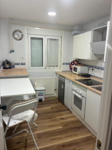 a kitchen with white cabinets and a wooden floor at Puentecuervo 3 in Pancorbo