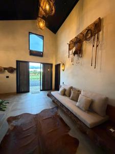a living room with a couch and a tv on the wall at Rancho Mavi Hospedagem Colônia Witmarsum in Palmeira