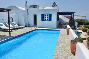 a villa with a swimming pool in front of a house at Villa H - Kamari Village in Kastraki
