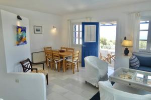 a living room with a table and a dining room at Villa H - Kamari Village in Kastraki
