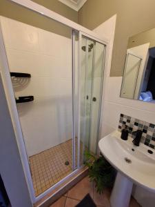 a bathroom with a shower and a sink at Cozy City Studio Escape in Centurion +3 photos
