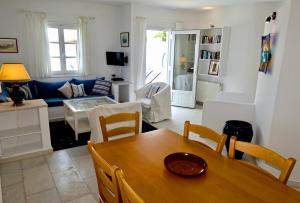 a living room with a table and a blue couch at Villa H - Kamari Village in Kastraki