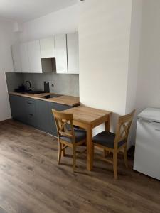 a kitchen with a wooden table and two chairs at Hostel Granat in Czekanów