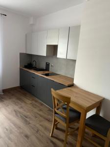 a kitchen with a wooden table and a wooden chair at Hostel Granat in Czekanów