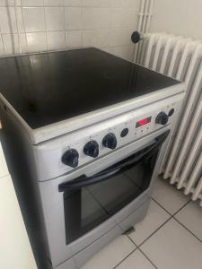 a stove top oven with a black counter top at Grande Chambre avec parking possible en supplément, BORDEAUX BASTIDE in Bordeaux