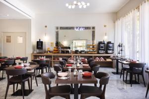 un ristorante con tavoli, sedie e uno specchio di Hôtel Locarno Nice a Nizza