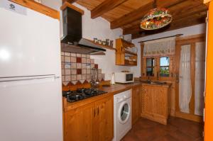 a kitchen with a stove and a washer and dryer at Las Calas de Valleseco in Valleseco