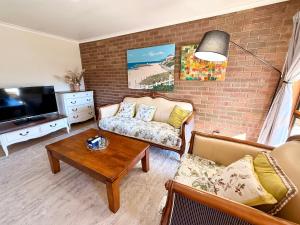 a living room with a couch and a tv at Unit 4 - Stawell, Golden Patch Retreat in Stawell