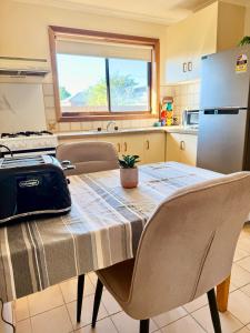 a kitchen with a table and a refrigerator at Unit 4 - Stawell, Golden Patch Retreat in Stawell