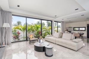 a living room with a white couch and a table at Dapple Villa in Na Mueang