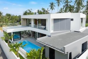 an aerial view of a white house with a swimming pool at Dapple Villa in Na Mueang