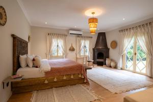 a bedroom with a large bed and a fireplace at Bab Akoul Palmeraie - Boutique Hotel & Spa in Marrakesh +150 photos