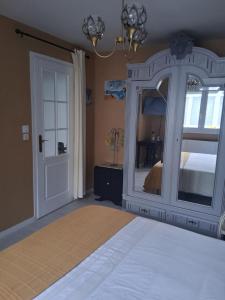 a bedroom with a large bed and a mirror at La petite maison in Saint-Martin-lez-Tatinghem