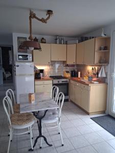 a kitchen with a table and chairs in it at La petite maison in Saint-Martin-lez-Tatinghem