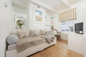 a living room with a couch and a television at Walters on The Digey - 100m to beach - pets allowed in St Ives