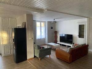 a living room with a couch and a tv at Le Loft Dolois, Maison Loft in Dole