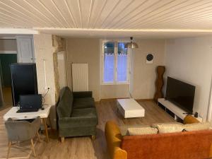 a living room with a couch and a tv at Le Loft Dolois, Maison Loft in Dole