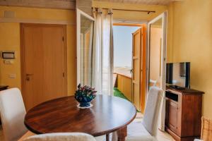 a dining room with a table and a television at Locanda Belvedere in Saludecio