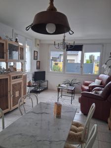 a living room with a table and a couch at La petite maison in Saint-Martin-lez-Tatinghem