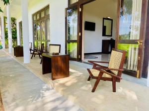 a living room with chairs and a table and a tv at Ayubowan Yala in Tissamaharama