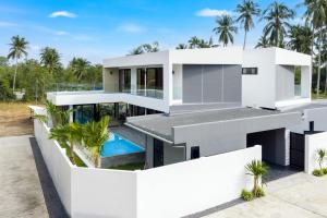a white house with a swimming pool and palm trees at Dapple Villa in Na Mueang +12 photos