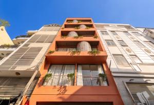 an orange building with potted plants on it at Saigon Maison 1988 BUI VIEN Centre in Ho Chi Minh City
