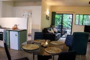 a kitchen and living room with a table and chairs at GREEN TREES CHALET Australia Zoo close by in Landsborough +20 photos