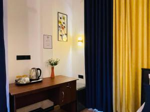 a room with a desk and a yellow curtain at Ella White Tea Garden Hotel in Ella