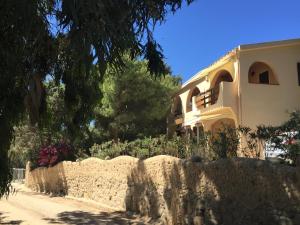 una casa detrás de una pared de piedra con flores en Villa Bonu, en Torre delle Stelle