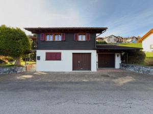 a black and white house with two garage doors at Chalet Marguerite in Flums