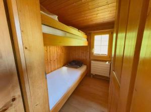 a small room with a bed in a wooden cabin at Chalet Marguerite in Flums