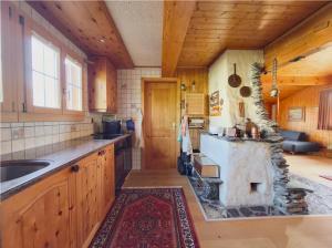 a large kitchen with a stone stove in it at Chalet Marguerite in Flums +6 photos