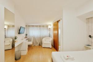 a white room with a bed and a bathroom at ABLA Guest House in Carcavelos