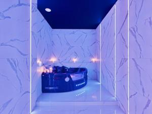 a bathroom with a tub in a room with marble walls at Jacuzzi LoveAparts Marki Romantic Getaway in Marki