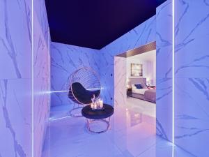 a room with a black chair and a table at Jacuzzi LoveAparts Marki Romantic Getaway in Marki